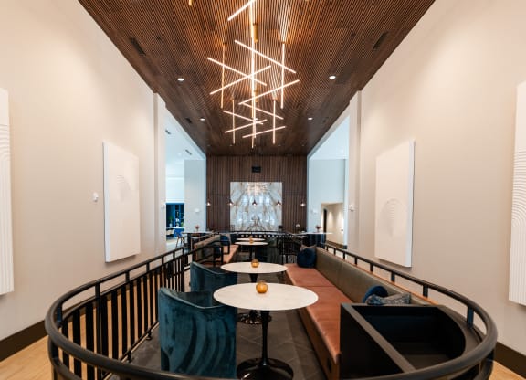a large lobby with tables and chairs and a large chandelier at Preston Ridge, Cary, NC